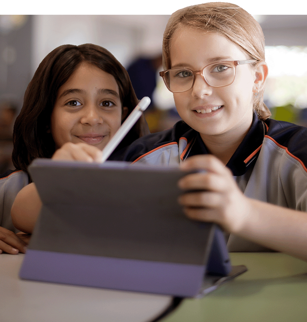 Two young female students using an iPad in their classroom learning.