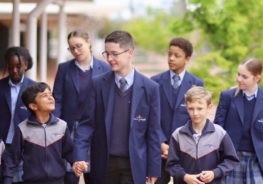 Students holding hands and walking through the campus